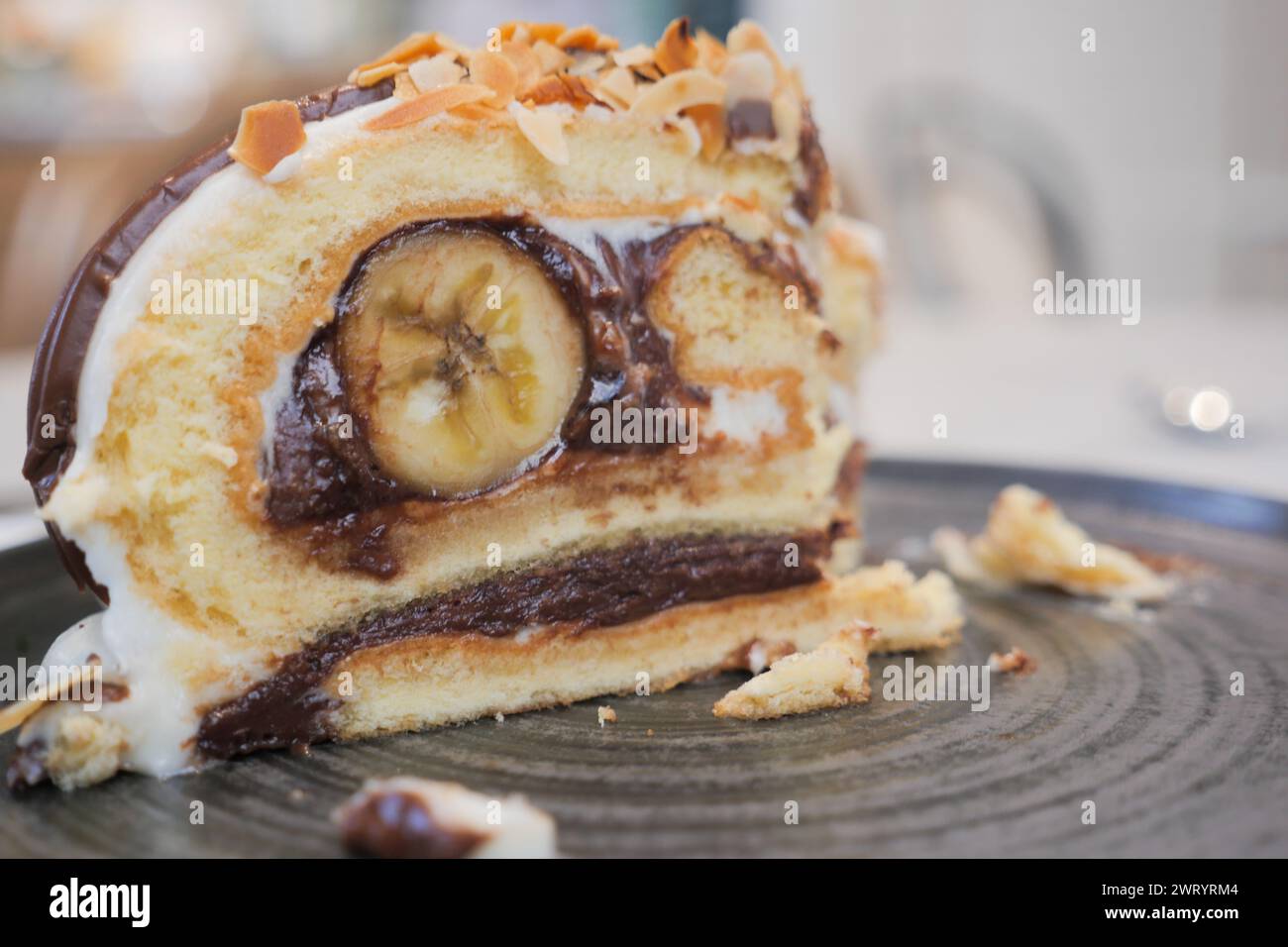 A slice of cake on serveware next to a glass of tea drinkware Stock Photo