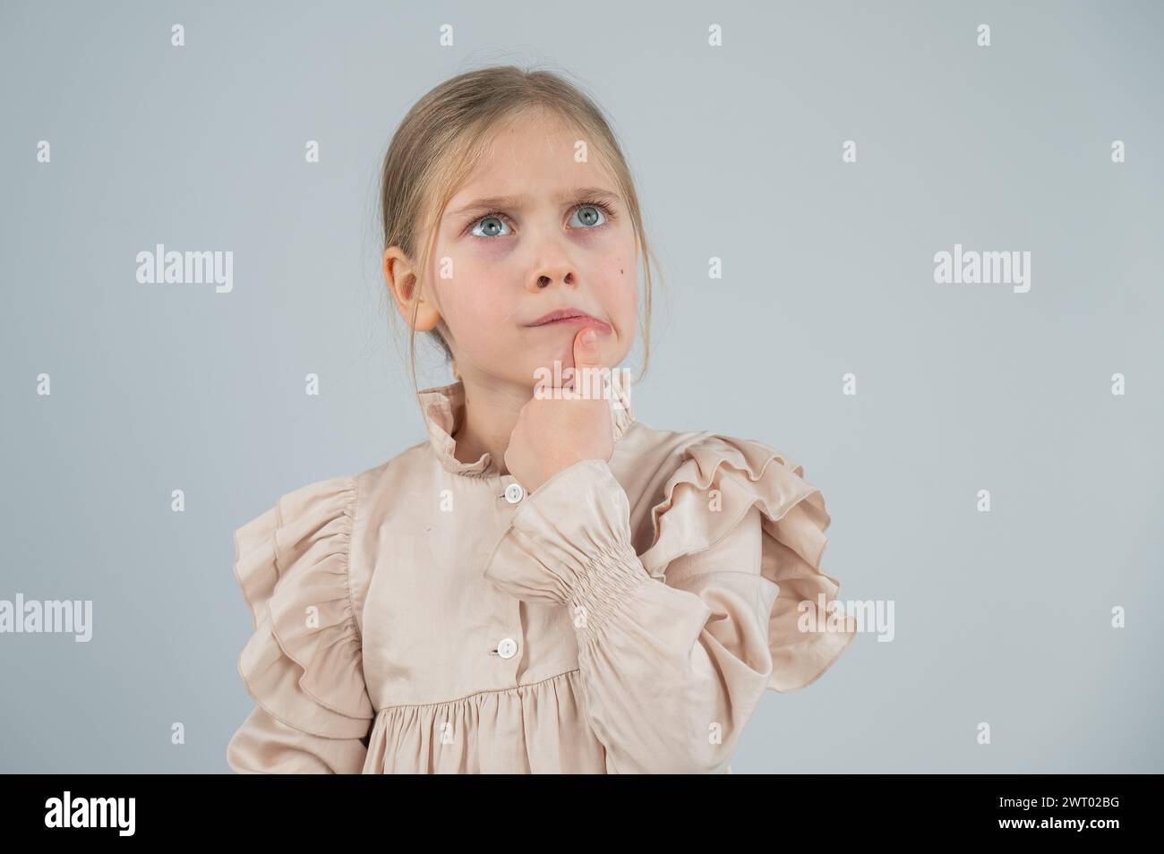 Portrait of a cute Caucasian pensive girl on a white background. Stock Photo