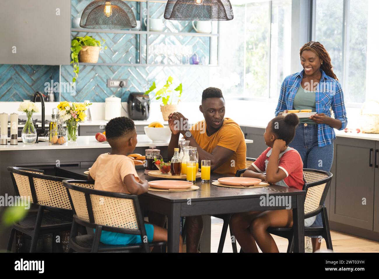 An African American family gathers around the kitchen table for a breakfast Stock Photo