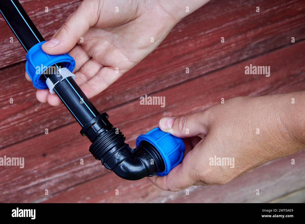 Installation of irrigation water supply using an elbow fitting with compression clamp. Stock Photo