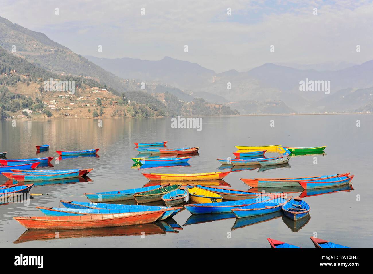 Still waters of the lake, Lake Pehwa with floating colourful boats and ...