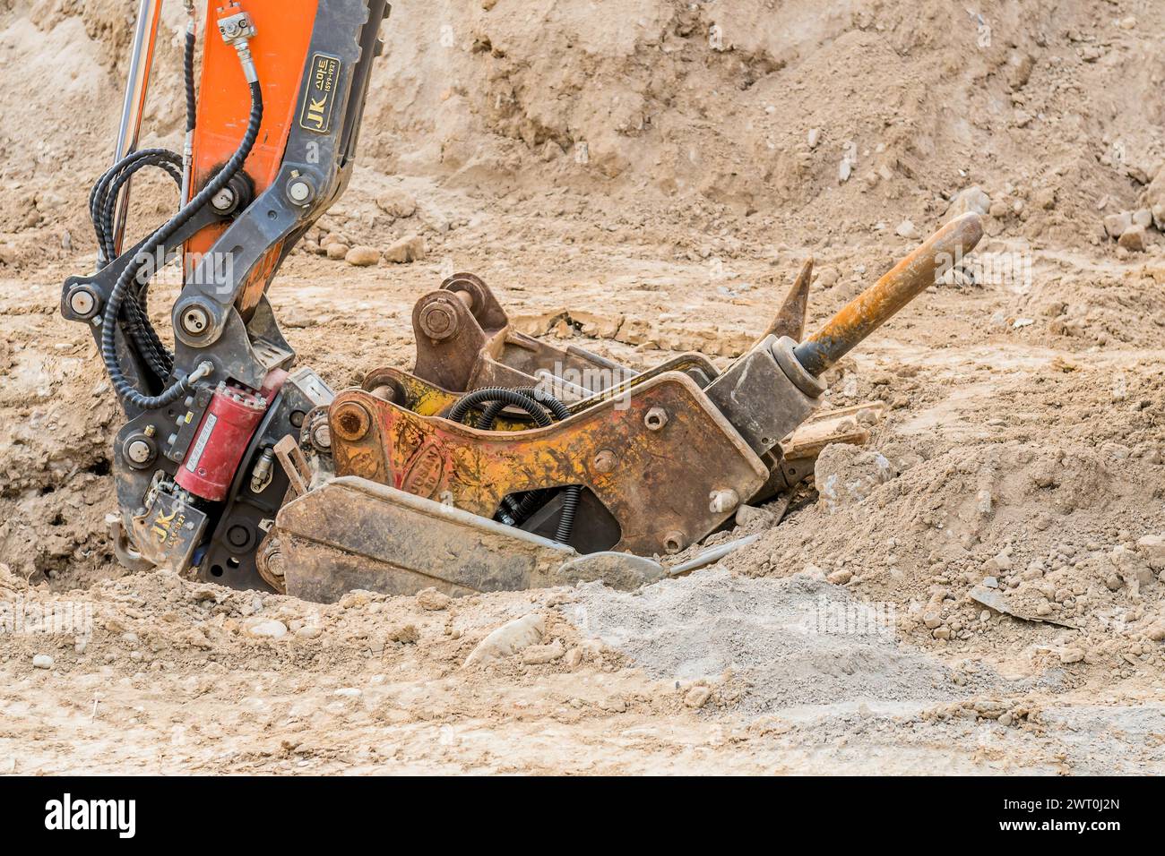 Jackhammer backhoe attachment sitting on dirt ground at construction site in Daejeon South Korea Stock Photo