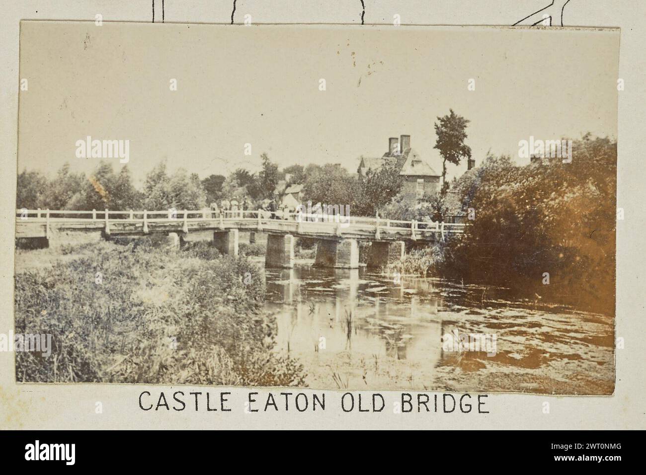 Castle Eaton Old Bridge. Henry W. Taunt, photographer (British, 1842 - 1922) 1897 One of three tipped-in photographs illustrating a printed map of Castle Eaton, Kempsford, and the surrounding area along the River Thames. The photograph shows a view of a wooden bridge over the river at Castle Eaton. Several men and women stand on the bridge looking out at the water. (Recto, mount) lower center, below image, printed in black ink: 'CASTLE EATON OLD BRIDGE' Stock Photo