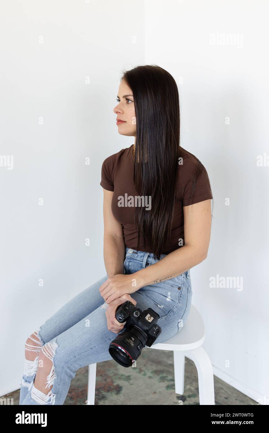 Contemplative photographer holding a Canon camera Stock Photo