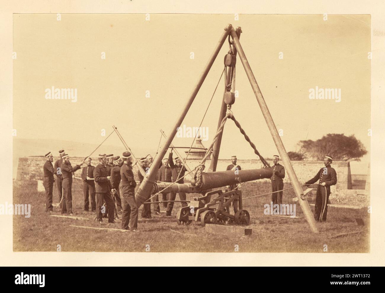 Fifeshire Artillery Militia assembling cannon. Possibly Thomas Rodger, photographer (Scottish, 1832 - 1883) about 1860s–1870s Members of the Fifeshire Artillery Militia gathered around a large tripod which is suspending a cannon. The cannon is held by ropes and a pulley attached to the center of the tripod. (Verso, mount) upper right, pencil: '20'; Stock Photo