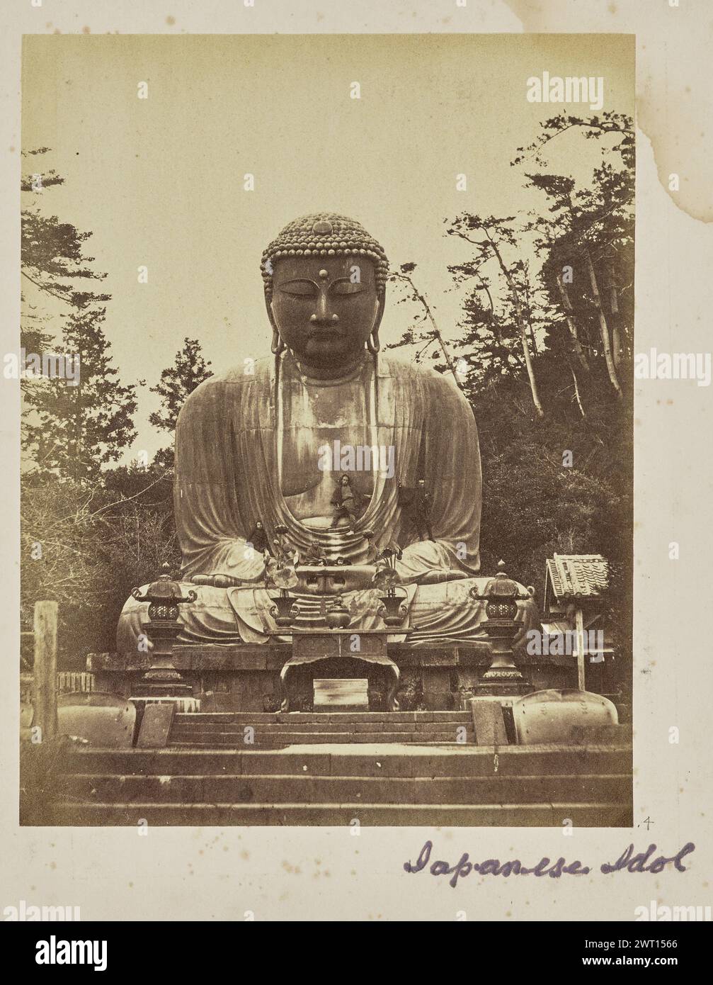 Japanese Idol. Unknown, photographer 1860s–1870s View of the 'Great Buddha' statue at the Kotoku-in Buddhist Temple, a monumental bronze statue depicting a seated Buddha. Five people can be seen sitting or standing on different parts of the statue. (Recto, mount) lower right, below image, in purple ink: 'Japanese Idol'; Stock Photo