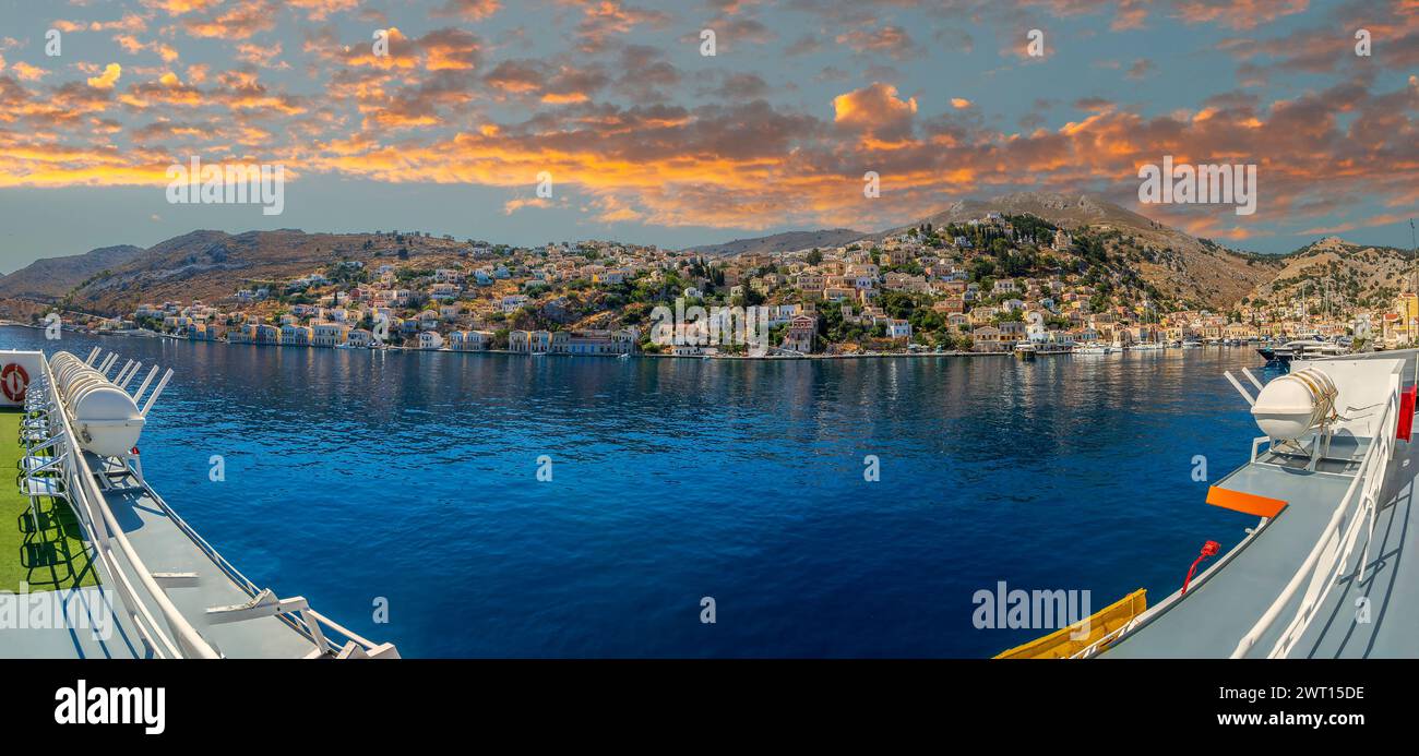 Symi harbour, with colorful neoclassical mansions covering the slopes near the main city. Part of the Dodecanese island chain. Sister city with Tarpon Stock Photo