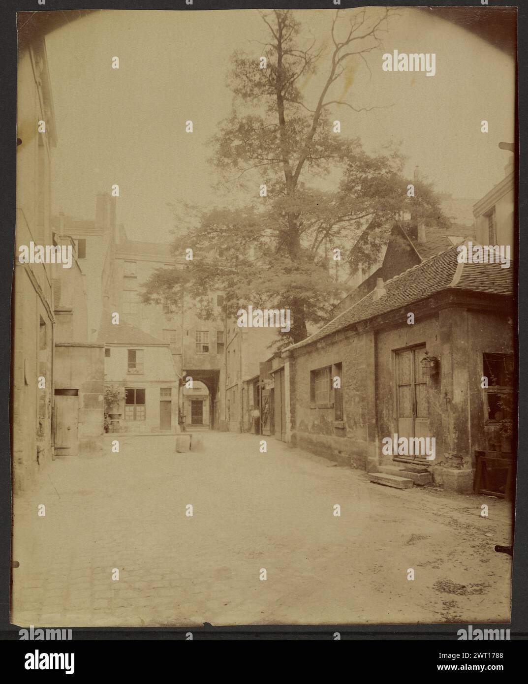 Ancien couvent des Carmélites, Rue Saint-Jacques, Va Disparaître. Eugène Atget, photographer (French, 1857 - 1927) 1899 Courtyard with random buildings and a large tree Inscription: Title and negative number '3672' inscribed verso print in pencil. Stock Photo
