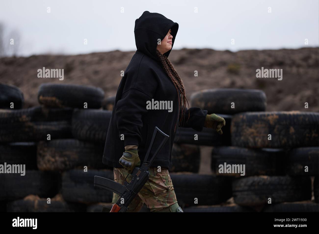 Ukrainian woman walks with a rifle on a shooting range. Military ...