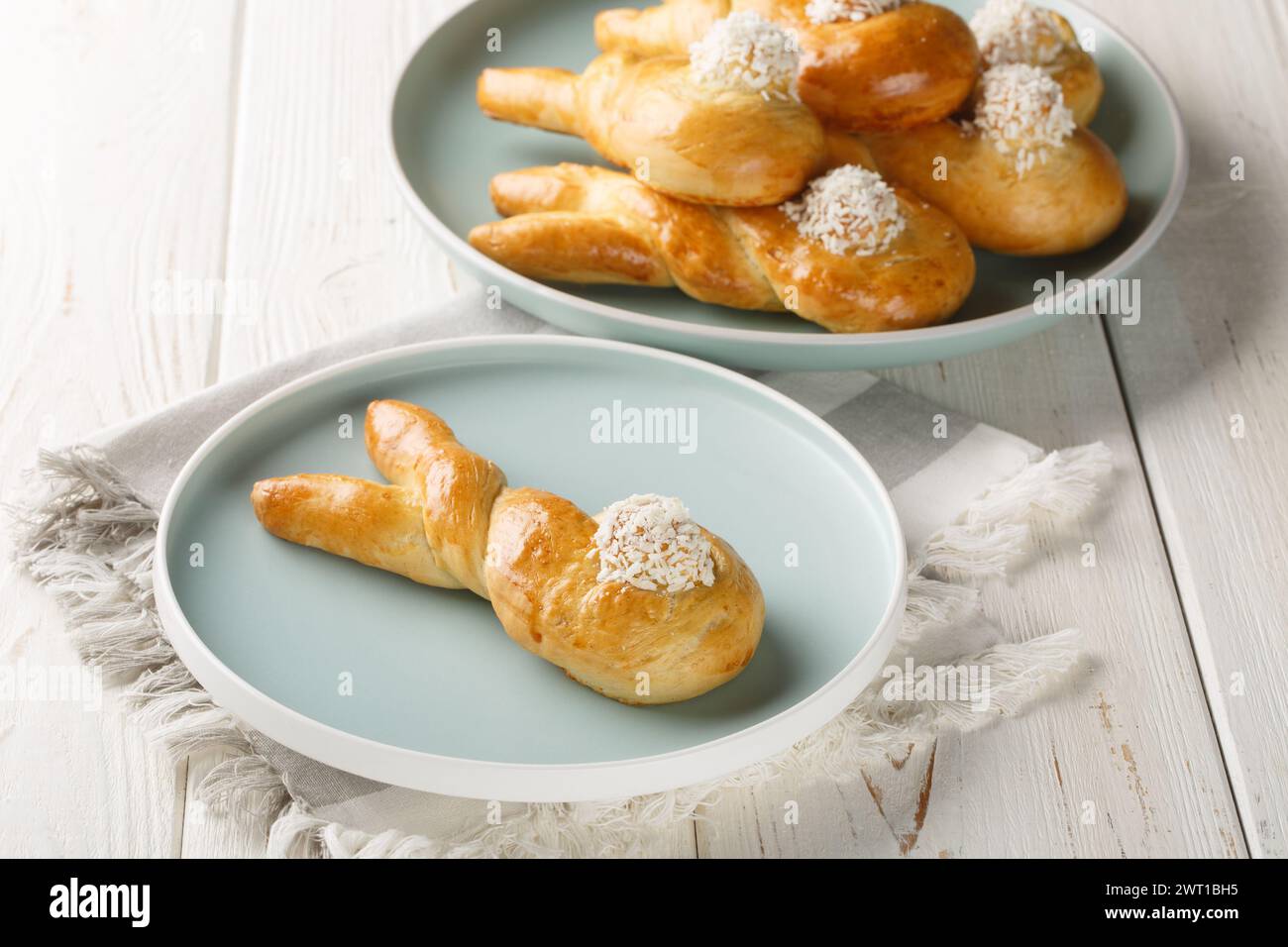 Freshly baked easter bunny made from yeast dough closeup on the plate on the table. Horizontal Stock Photo