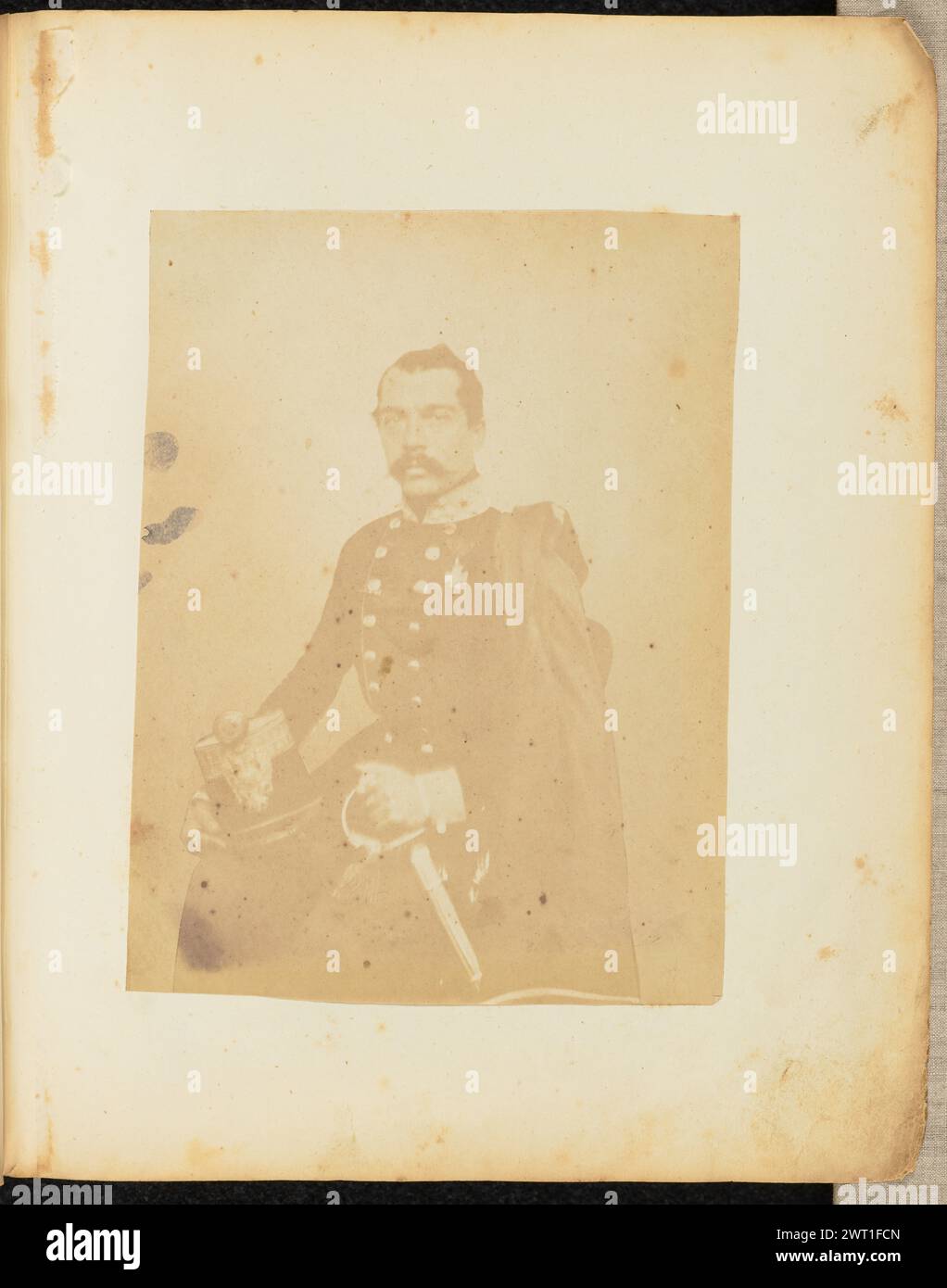 Portrait of a man in military uniform. Jakob Höflinger, photographer (Swiss, 1819 - 1898) about 1853–1857 A portrait of a man in an Austro-Hungarian military uniform. He is sitting and holding the hilt of his sword with one hand. He has a helmet in his other hand, resting on his leg. Stock Photo