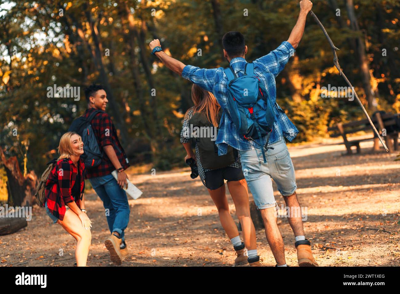 Group of four friends having fun hiking through forest together Stock ...