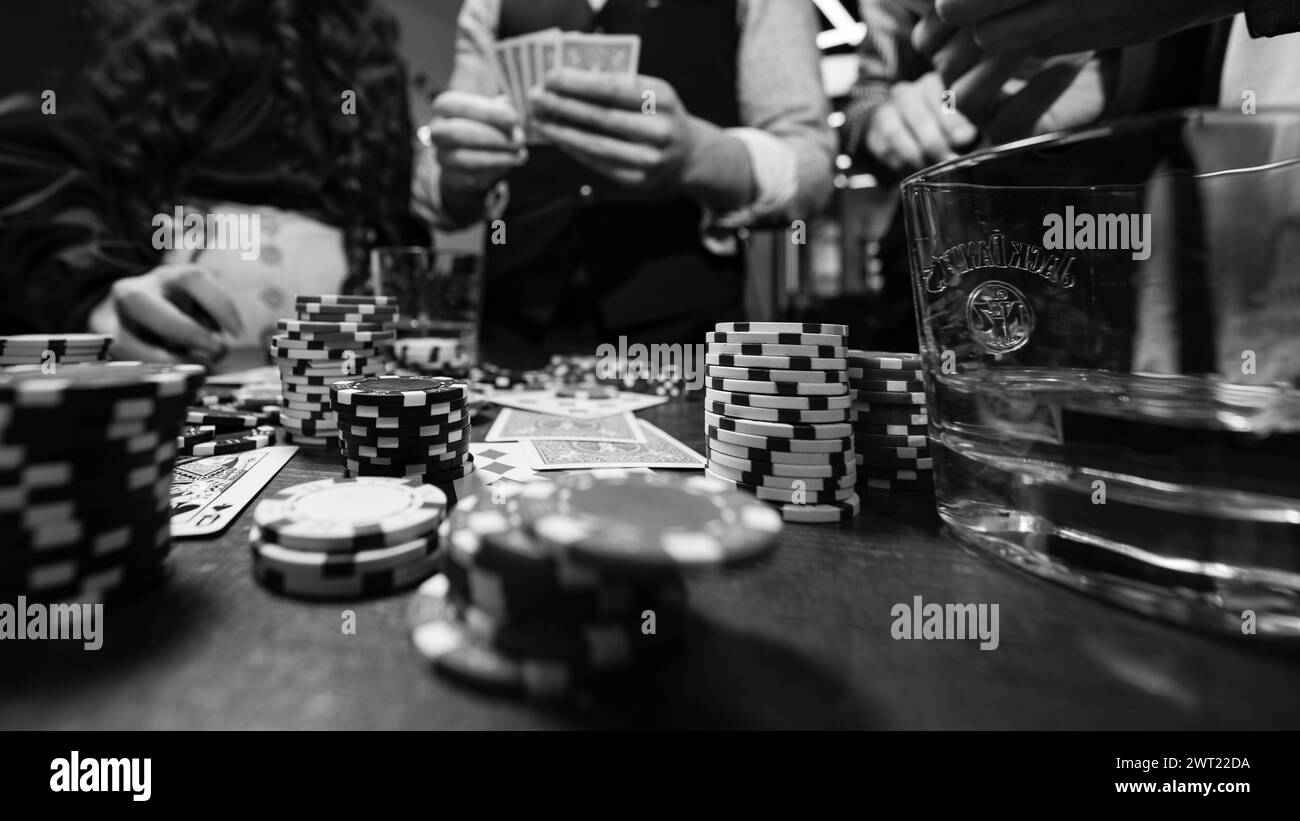 Ivano-Frankivsk, Ukraine February 23, 2024: five young people playing poker and drinking jack daniels whiskey, team in barbershop. Stock Photo