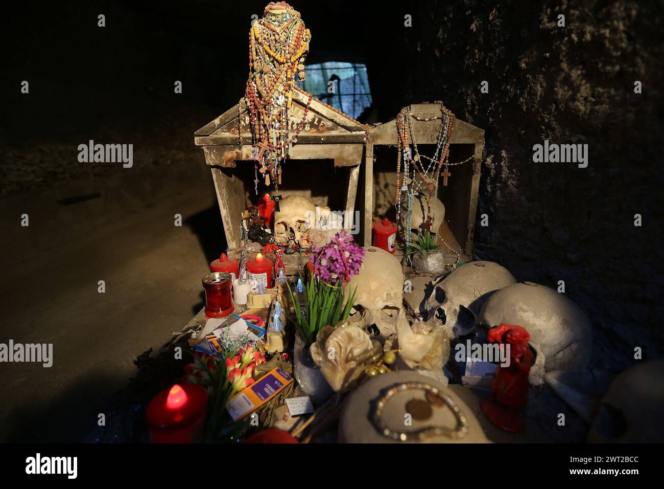 A small altar made of objects and money left by the faithful as a sign of devotion, in the Fontanelle cemetery. Over 40,000 skulls and skeletons of pe Stock Photo