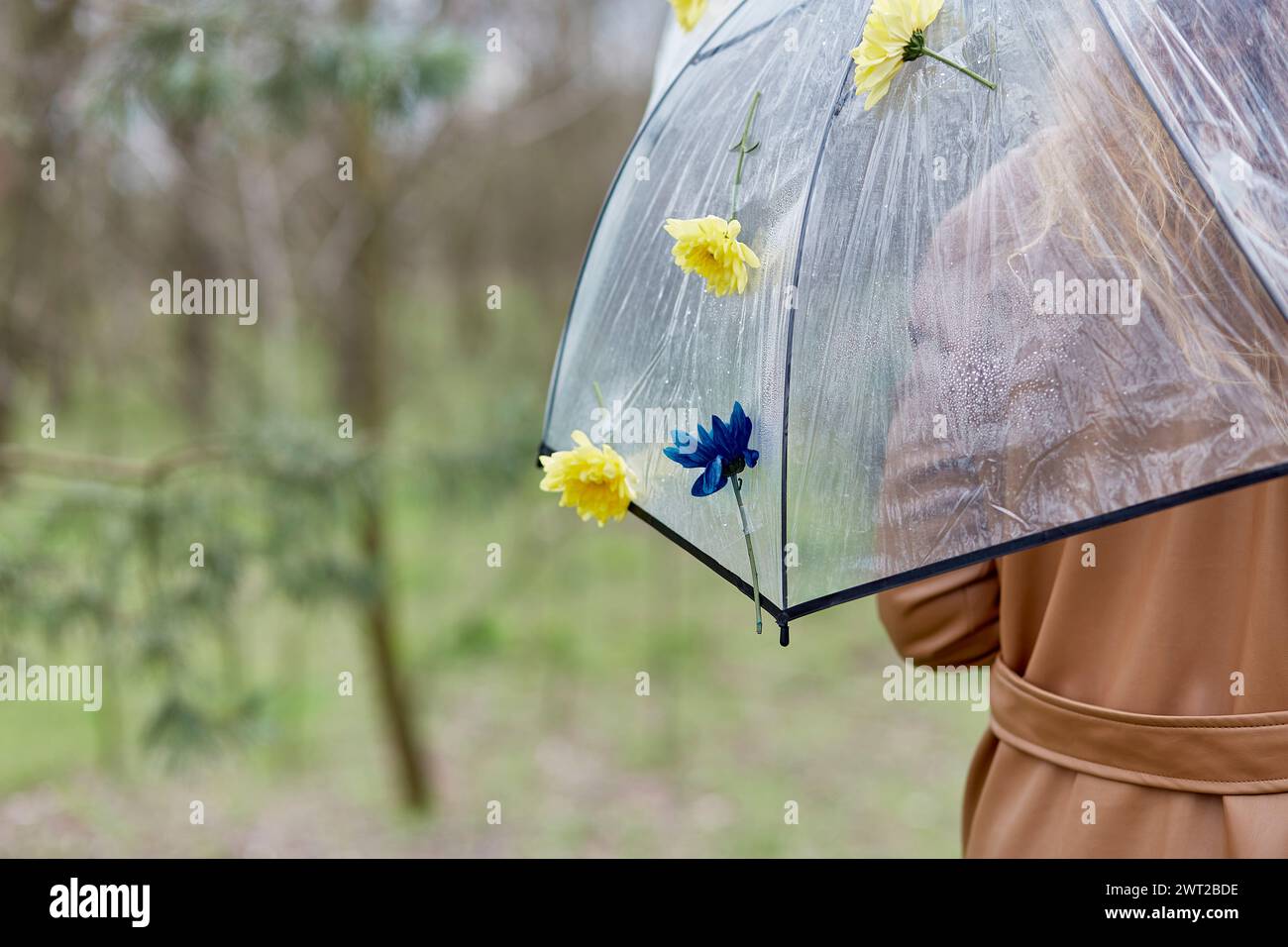 Woman under permanent umbrella adorned with fresh flowers. Symbol for spring fashion and rainwear collections. AI Illustration Stock Photo