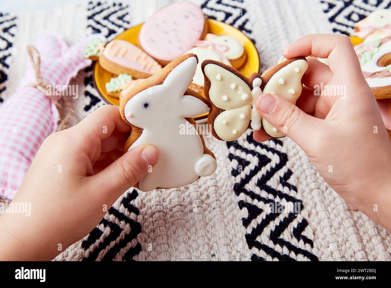 Background of happy Easter traditions is formed by the childs hands holding Easter cookies Stock Photo