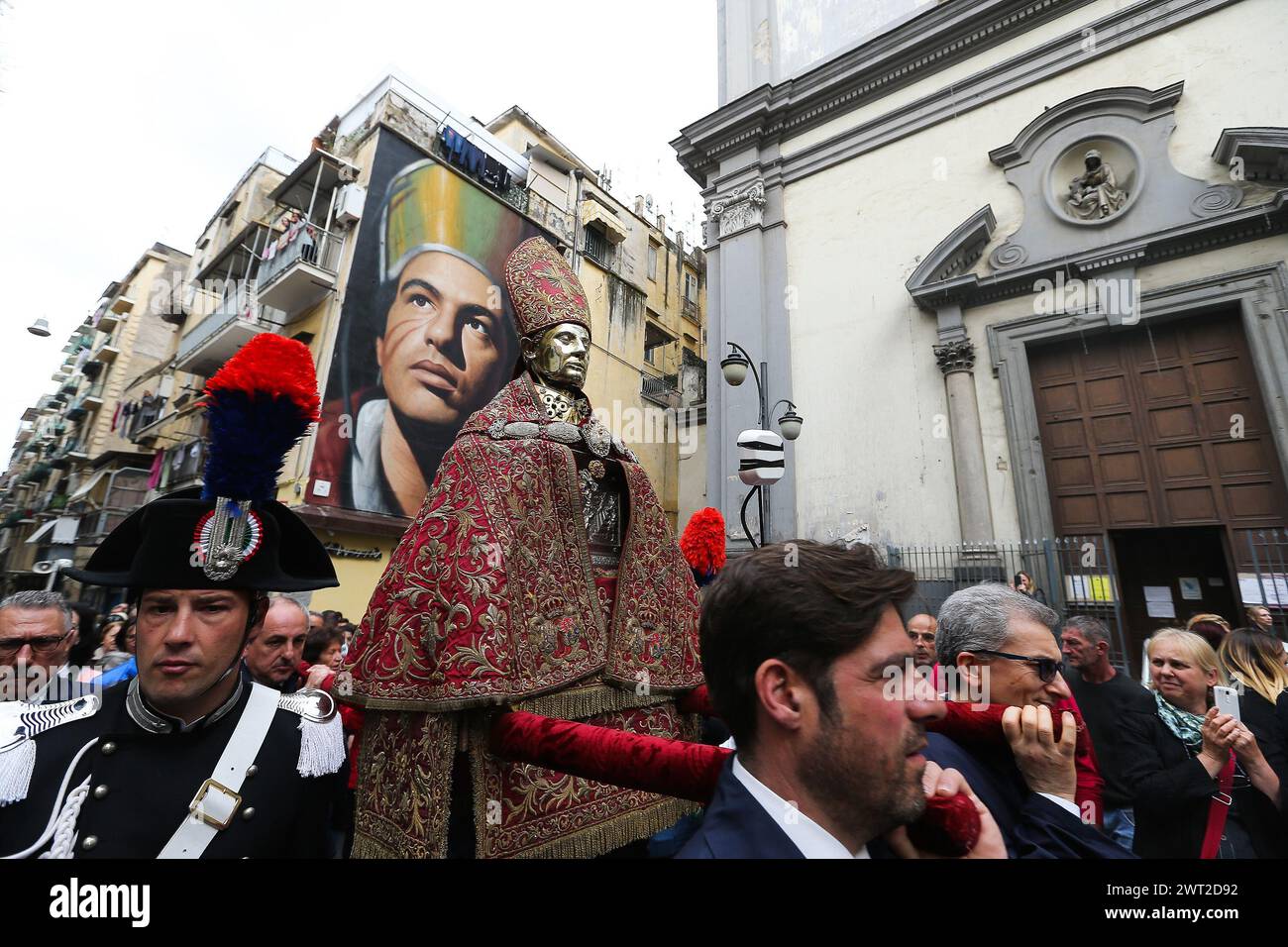 The bust of San Gennaro during the procession of the patron saint in the streets of Naples. Behind, the murales depicting San Gennaro by the artist Jo Stock Photo