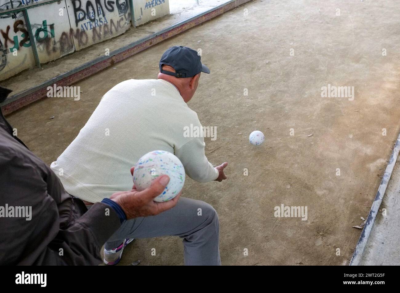 A man playing bowls during a competition in a sports facility in Aversa Stock Photo