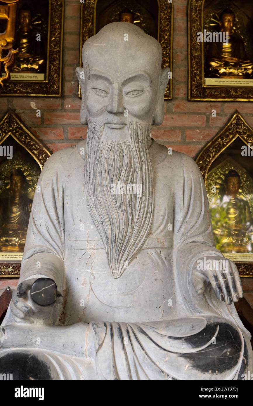 Closeup of one of many stone, Buddhist statues in a meditation pose in the Bai Dinh temple pagoda complex in Ninh Binh, northern Vietnam. Stock Photo