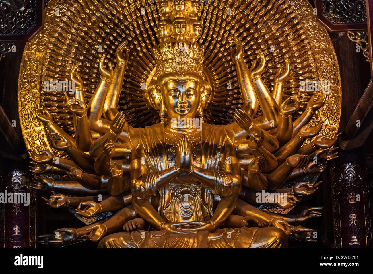 Large, ornate, gold Buddha statue with multiple arms in the Bai Dinh Pagoda temple complex, Trang An, Ninh Binh province, northern Vietnam. Stock Photo