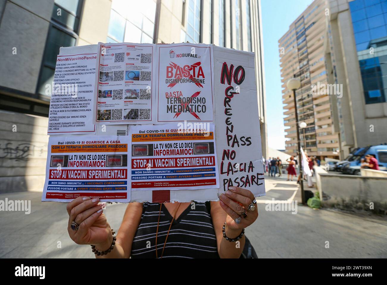 A woman protests with a placard, in front of the seat of the regional council of Campania, against the entry into force of the Green Pass, the precaut Stock Photo