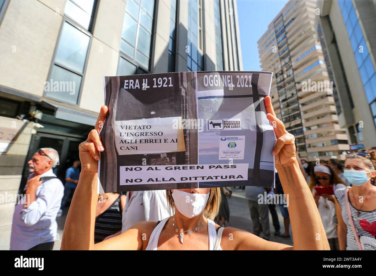 A woman protests with a placard, in front of the seat of the regional council of Campania, against the entry into force of the Green Pass, the precaut Stock Photo