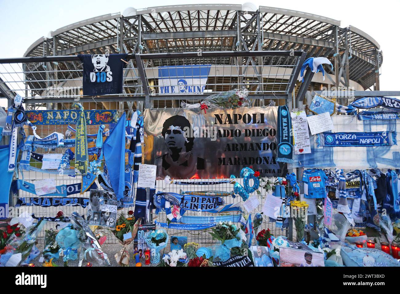 Memorabilia and tealights of Diego Armando Maradona, with a giant plaque that names the stadium to the champion, in front of the San Paolo stadium in Stock Photo