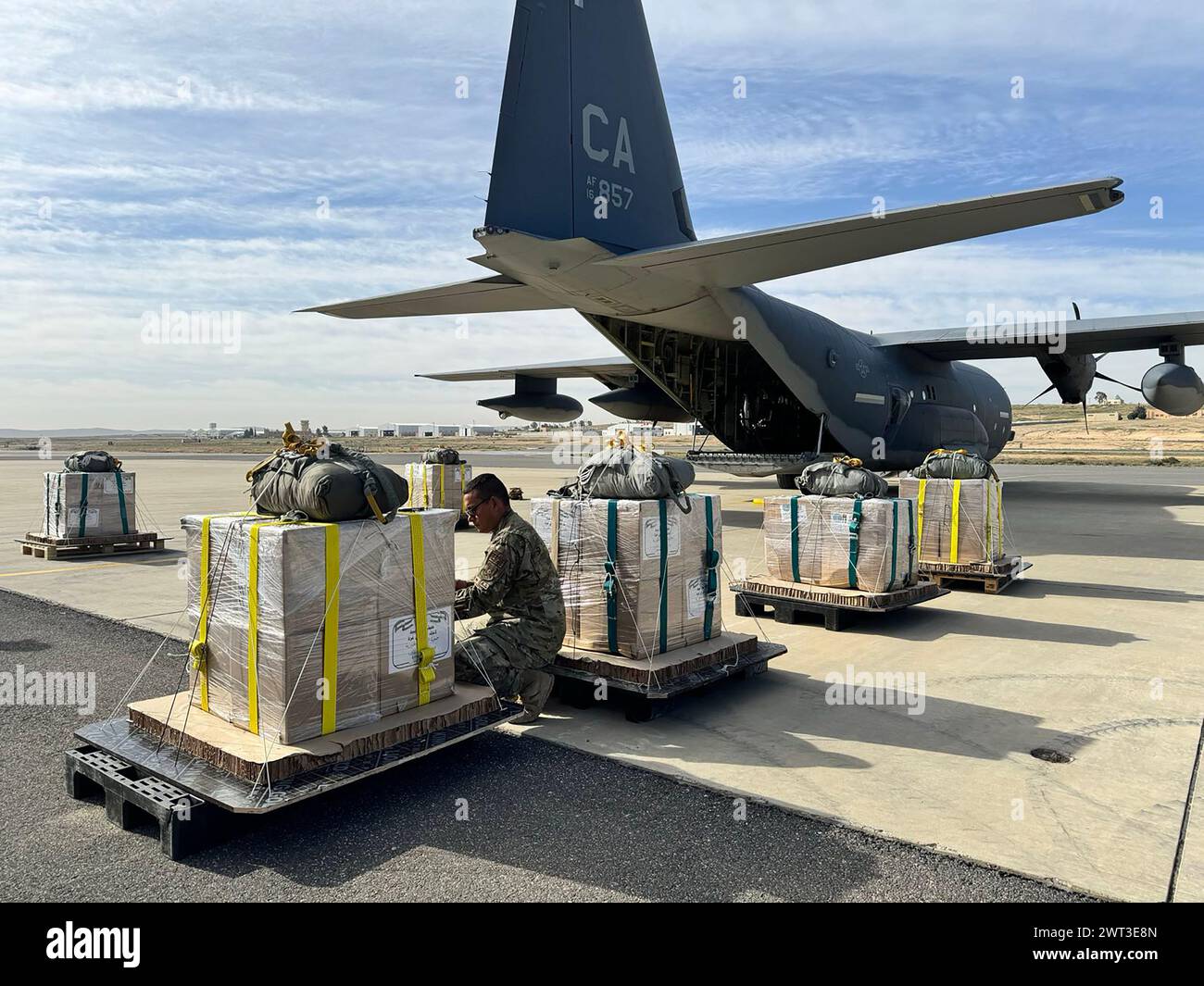 U.S. Air Force loadmasters prepare humanitarian aid for airdrop by a U.S. Air Forces Central HC-130J Combat King II Stock Photo