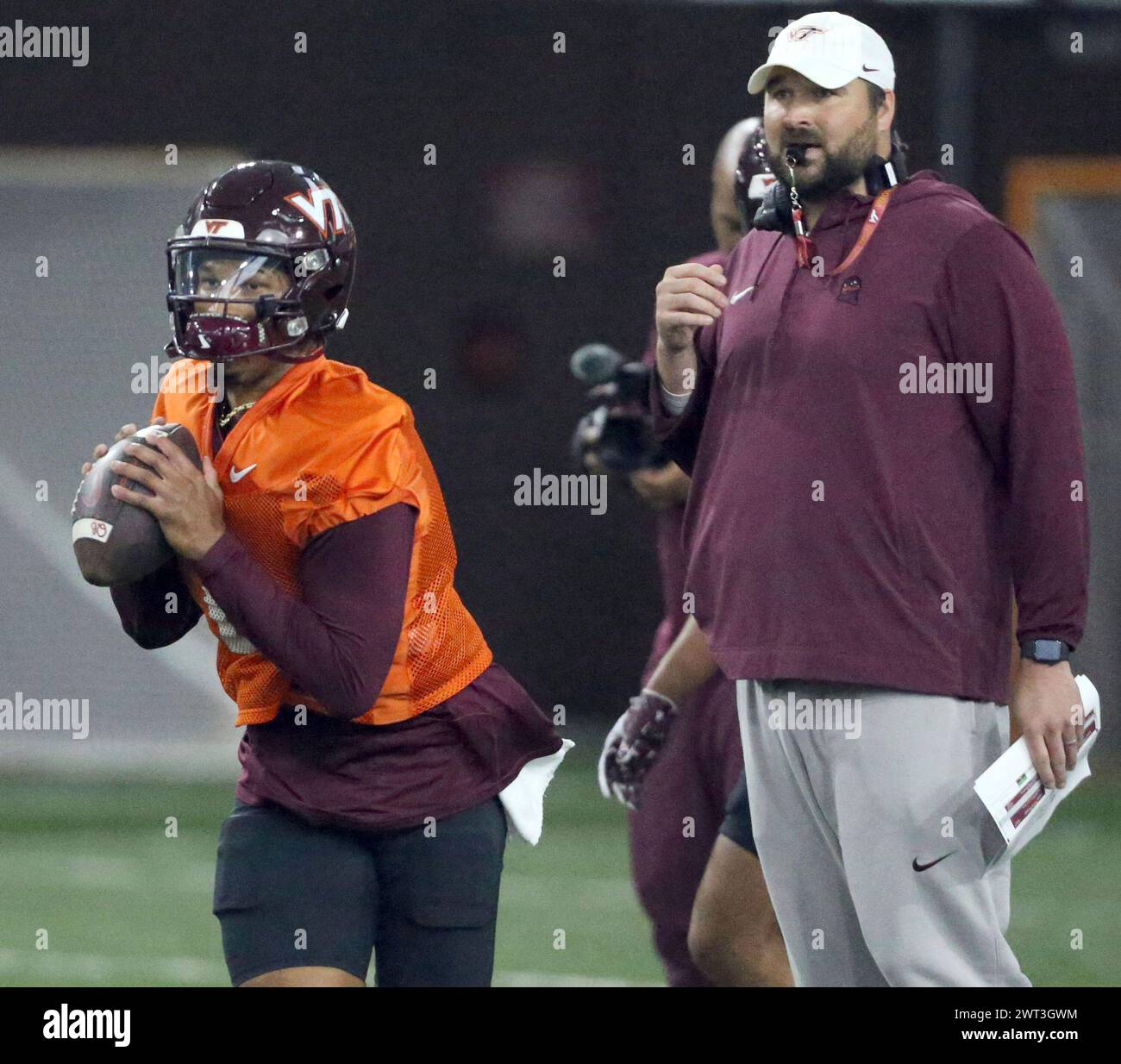 Virginia Tech quarterback Kyron Drones (1) rolls out to throw while offensive coordinator Tyler