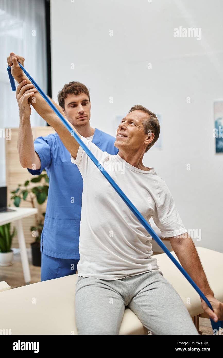attractive doctor in blue robe helping mature jolly patient to use ...
