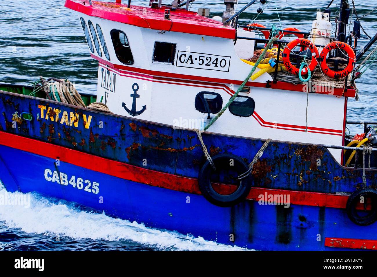 A colourfull fishing trawler along the Strait of Magellan. Strait of Magellan, is a channel linking the Atlantic and Pacific oceans. Stock Photo