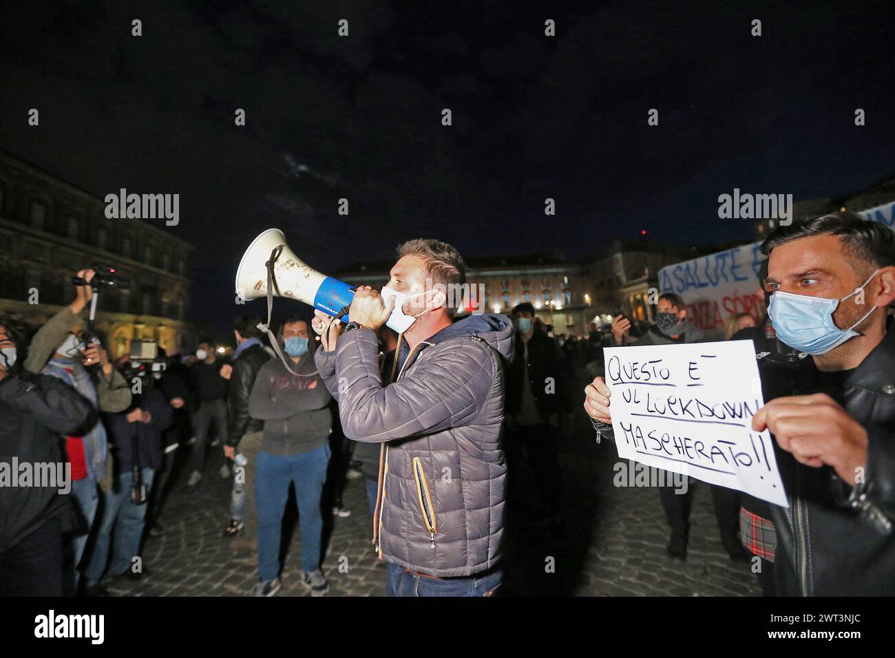 People with a placard and a megaphone protest against the partial lockdown measures of the Italian and Regional government, taken for the increase in Stock Photo
