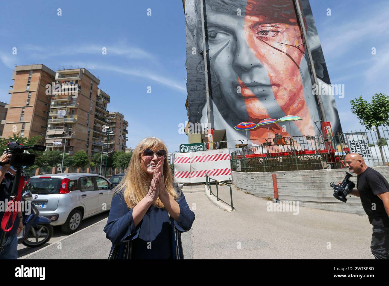 Dori Ghezzi, the singer, and widow of Fabrizio De Andrè, in front of the mural, by Jorit and Trisha, depicting the famous Italian singer-songwriter, o Stock Photo