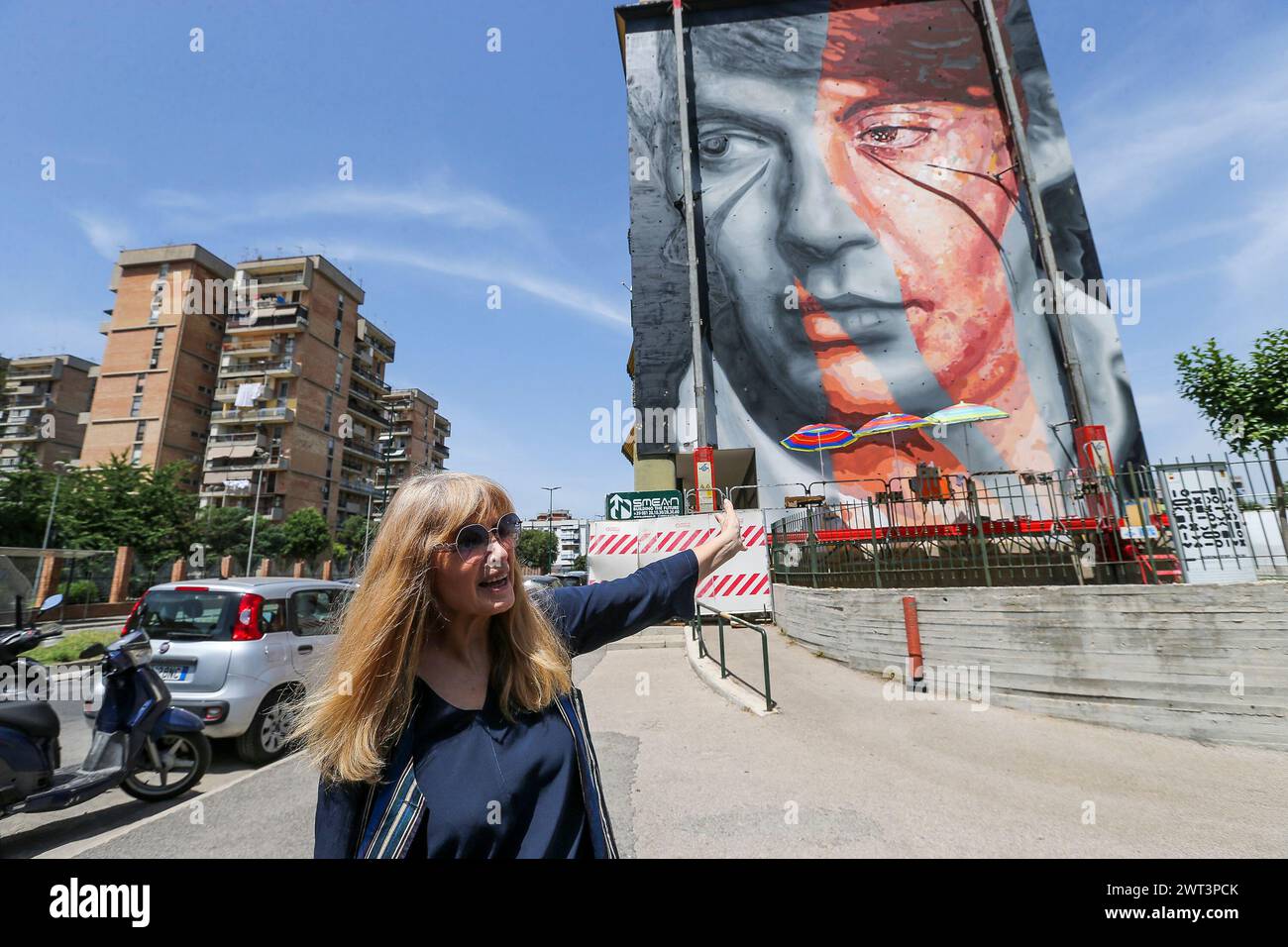 Dori Ghezzi, the singer, and widow of Fabrizio De Andrè, in front of the mural, by Jorit and Trisha, depicting the famous Italian singer-songwriter, o Stock Photo