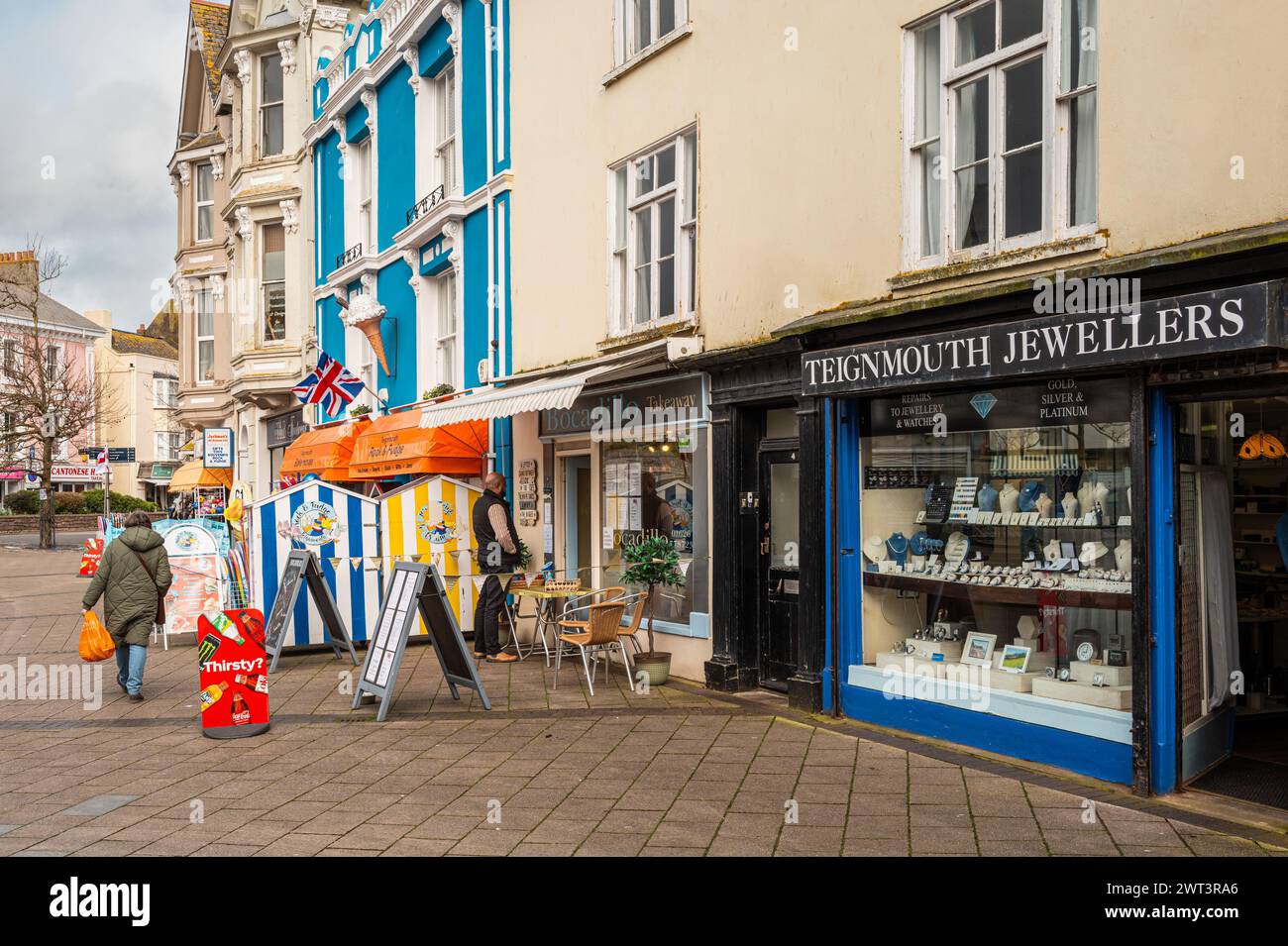 Teignmouth town centre shopping area with gift shop Two people and a gift shop and jewellers shop. Stock Photo