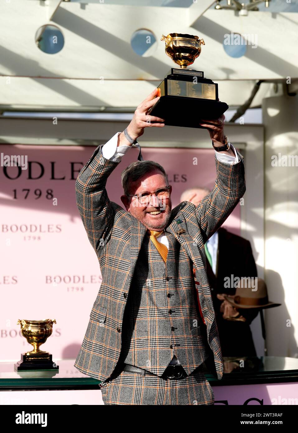 Greg Turley husband of owner Audrey Turley celebrates with the trophy after Galopin Des Champs ridden by jockey Paul Townend wins the Boodles Cheltenham Gold Cup Chase on day four of the 2024 Cheltenham Festival at Cheltenham Racecourse. Picture date: Friday March 15, 2024. Stock Photo