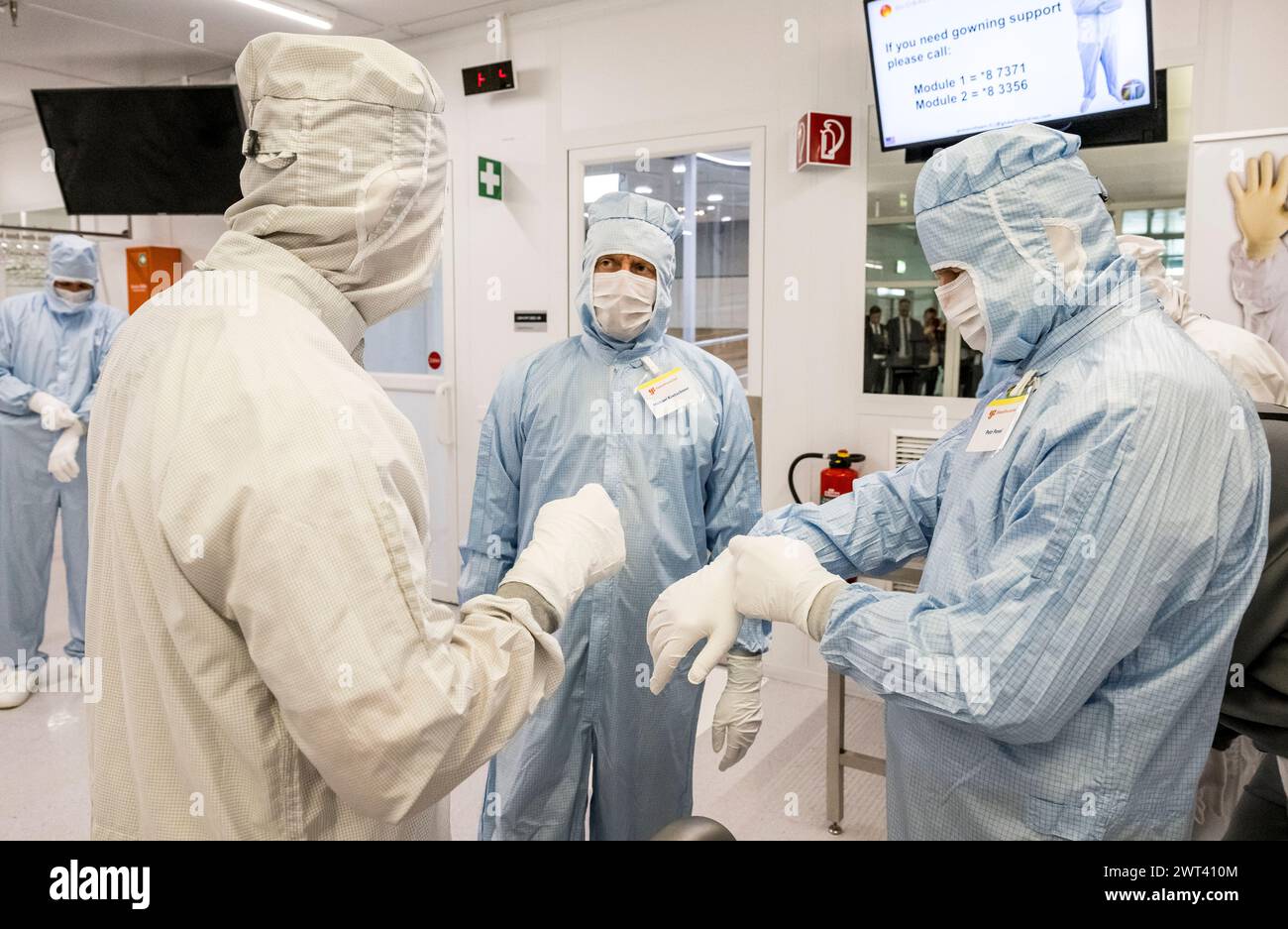 Drazdany, Germany. 15th Mar, 2024. Czech President Petr Pavel visited the GlobalFoundries microchip factory in Saxony, on March 15, 2024, in Dresden, Germany. Saxony's Prime Minister Michael Kretschmer (second from right) and President Petr Pavel (right) get dressed before touring the cleanroom. The 'cleanroom' is only accessible with anti-static suits and strict hygiene rules to prevent contamination of materials. Credit: Ondrej Hajek/CTK Photo/Alamy Live News Stock Photo