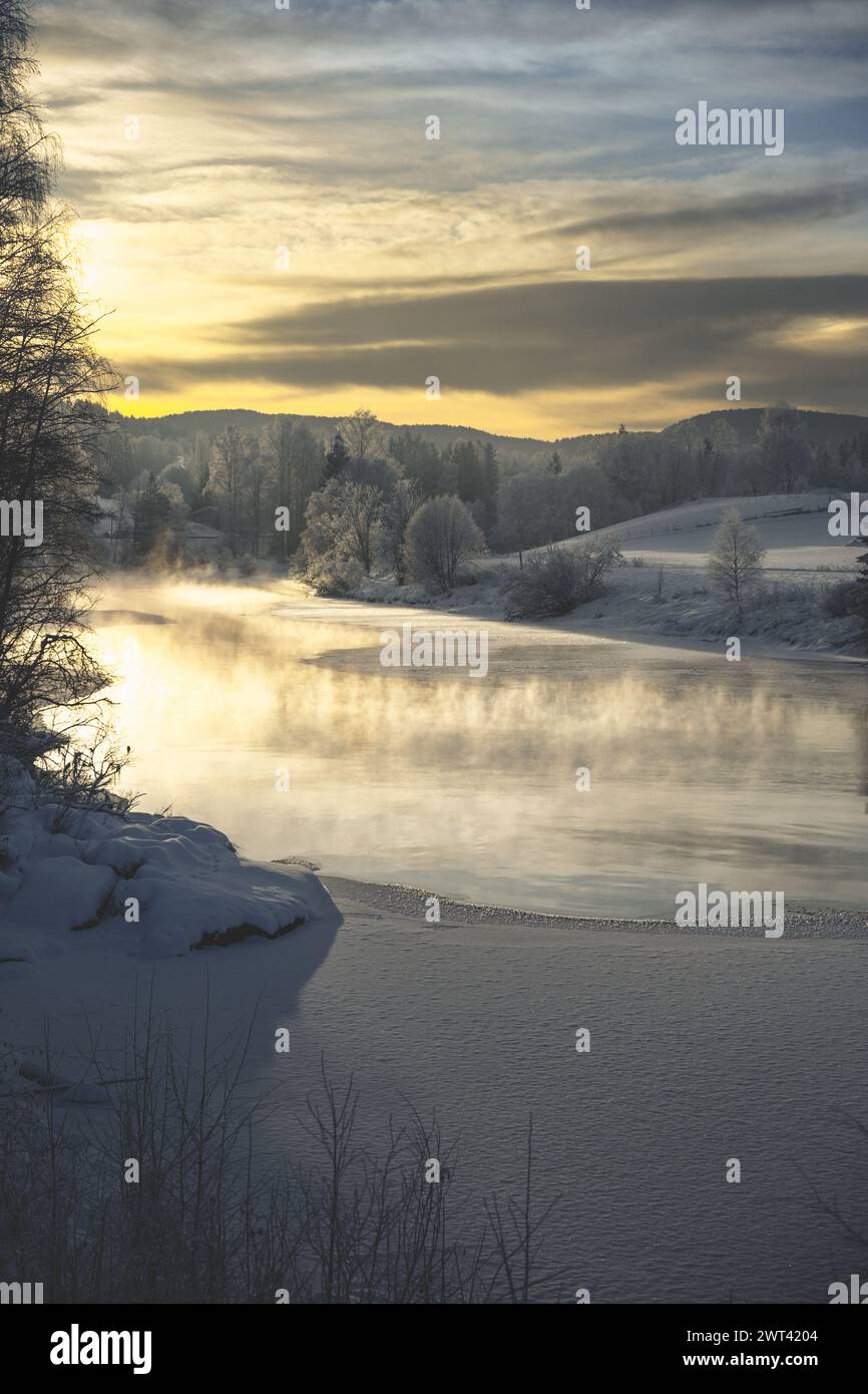 A scenic morning landscape with snowy river, fog, and trees Stock Photo ...