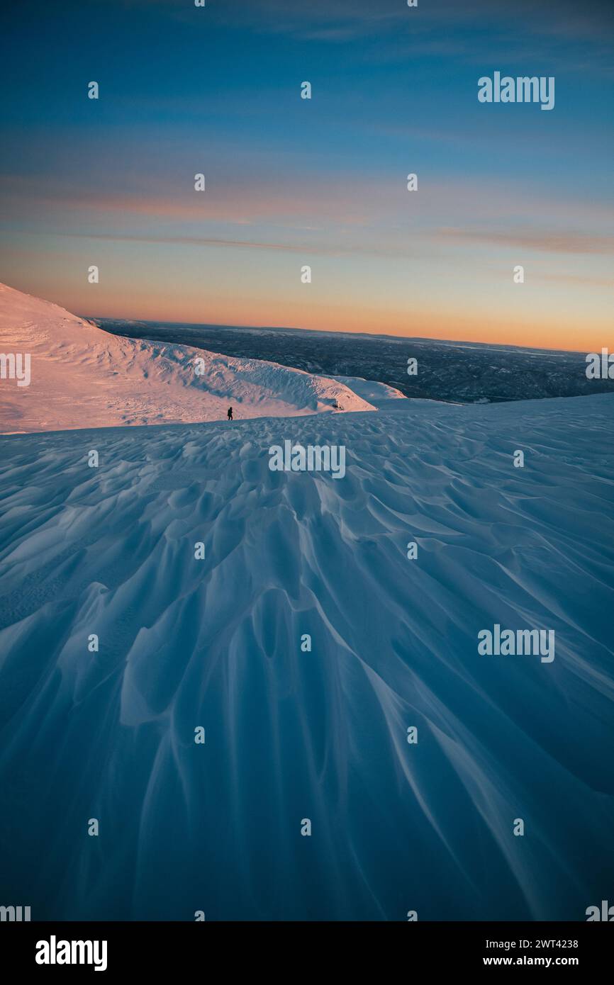 An aerial view of snow-capped mountain during sunset, captured with a handheld camera Stock Photo