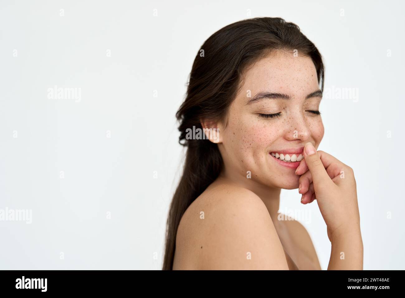 Happy Latin young woman with freckles on face isolated on white background. Stock Photo