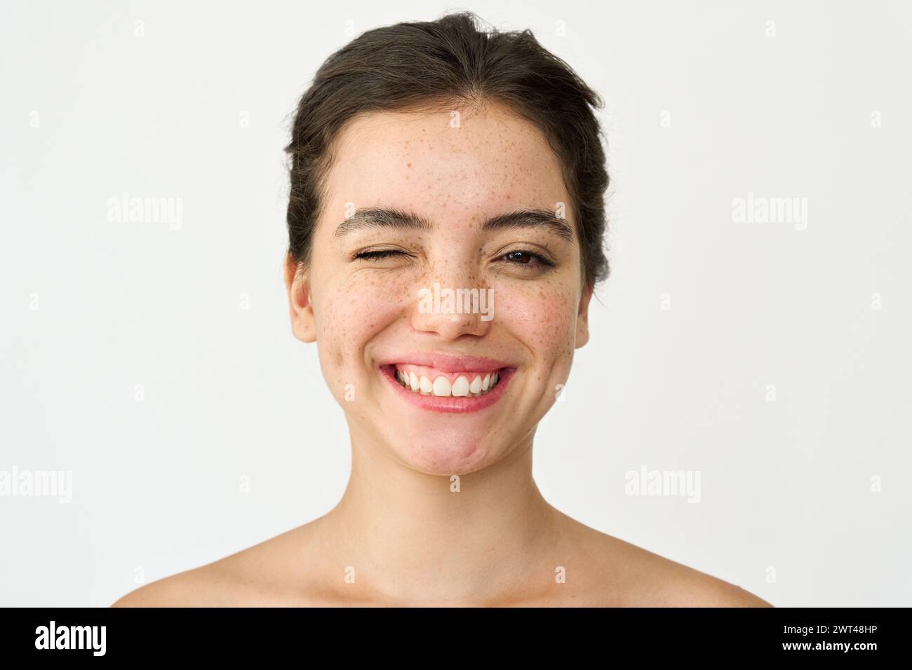 Happy Latin young woman freckled face winking isolated on white. Portrait. Stock Photo