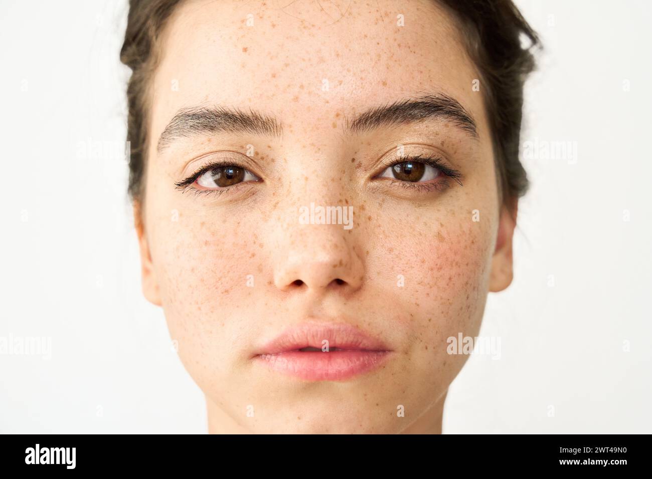 Close up beauty portrait of Latin girl with freckles on white background. Stock Photo