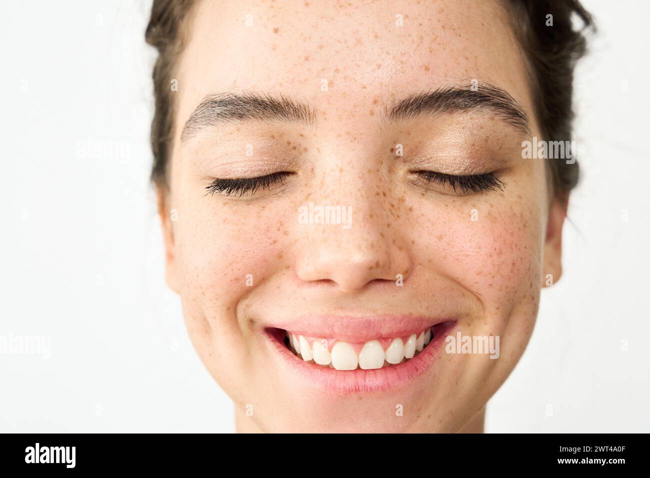 Happy Latin young woman freckled face isolated on white. Close up portrait. Stock Photo