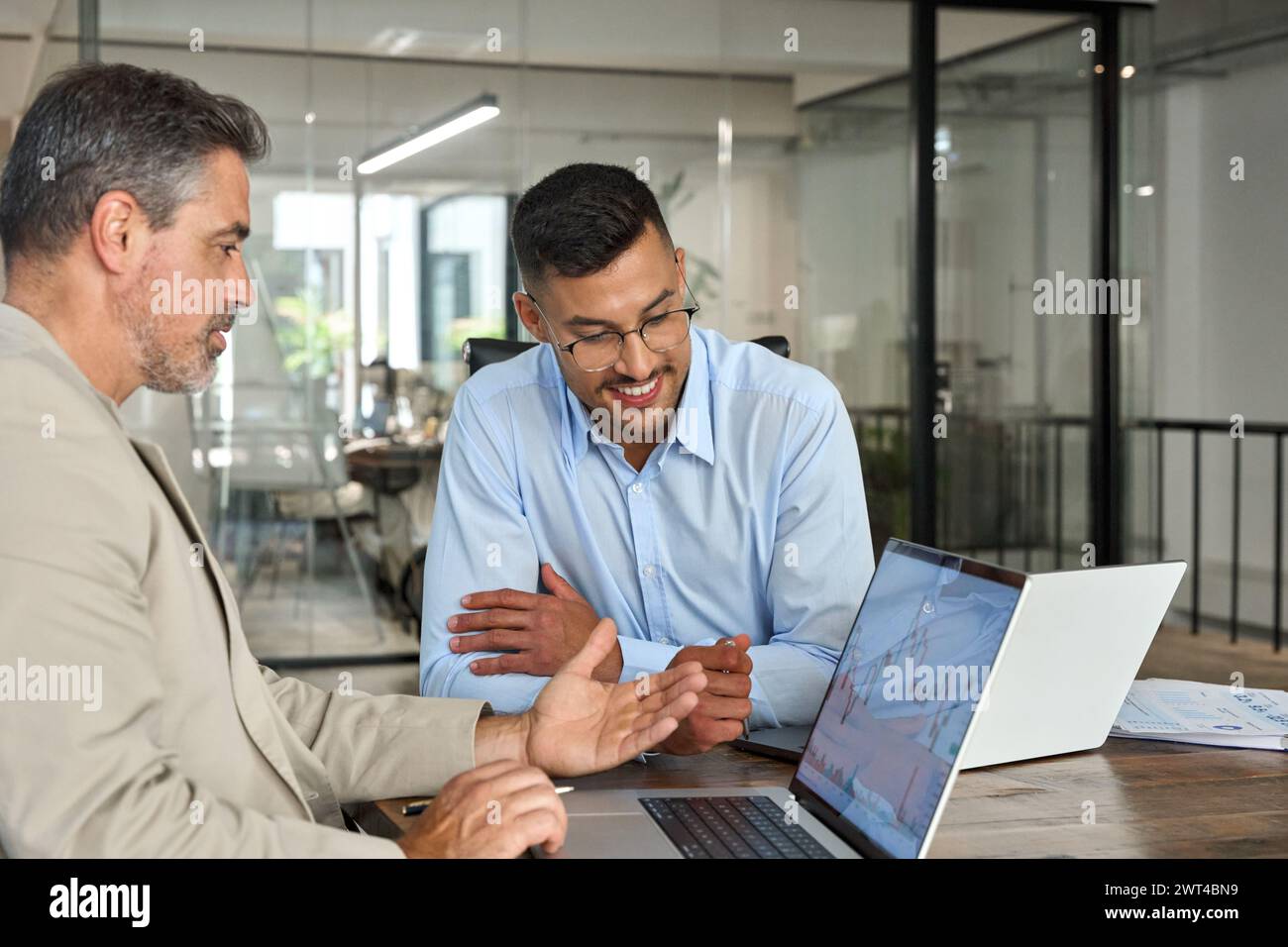 Advisor consulting investor about stock market financial investing using laptop. Stock Photo