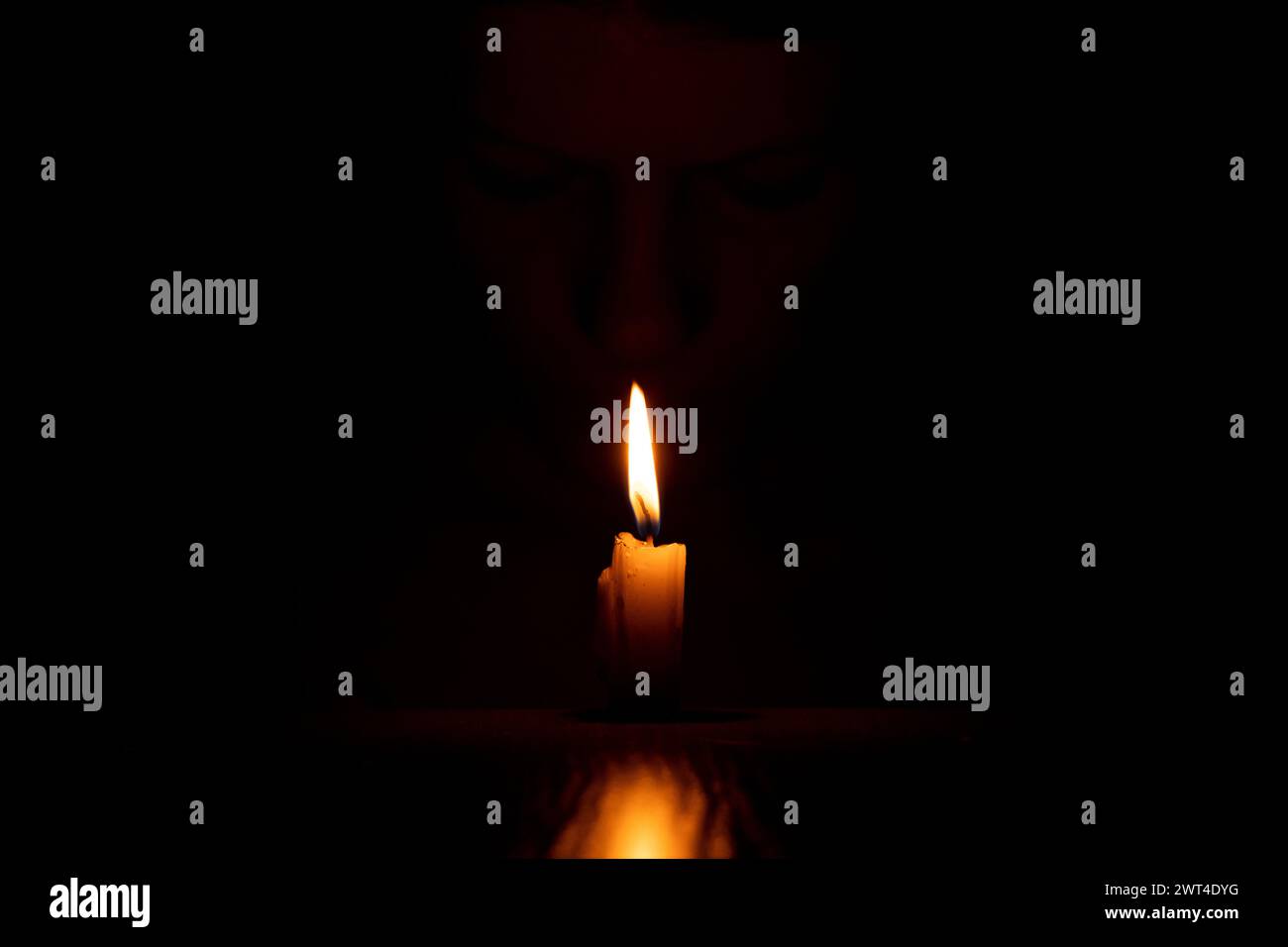 The face of a Ukrainian girl in the dark with a candle, a candle flame and a girl Stock Photo