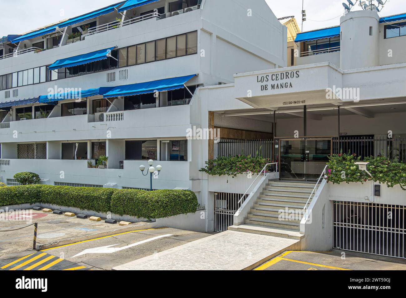 Cartagena, Colombia - July 25, 2023: Los Cedros de Manga upscale apartment building along Calle 29. Gray facade with blue awnings and green foliage Stock Photo