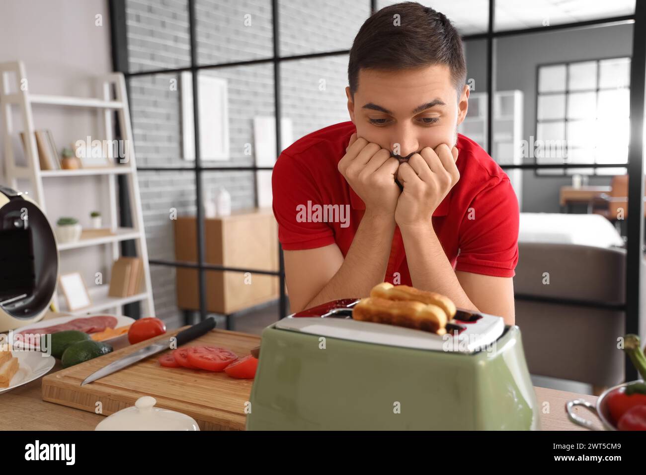Impatient young man waiting for toasts in toaster at home Stock Photo ...