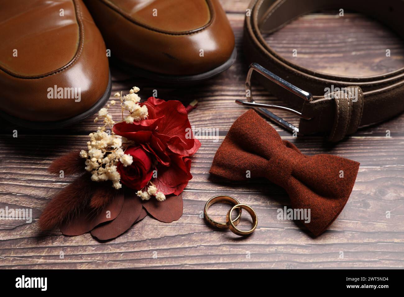 Wedding stuff. Composition with stylish boutonniere on wooden background, closeup Stock Photo