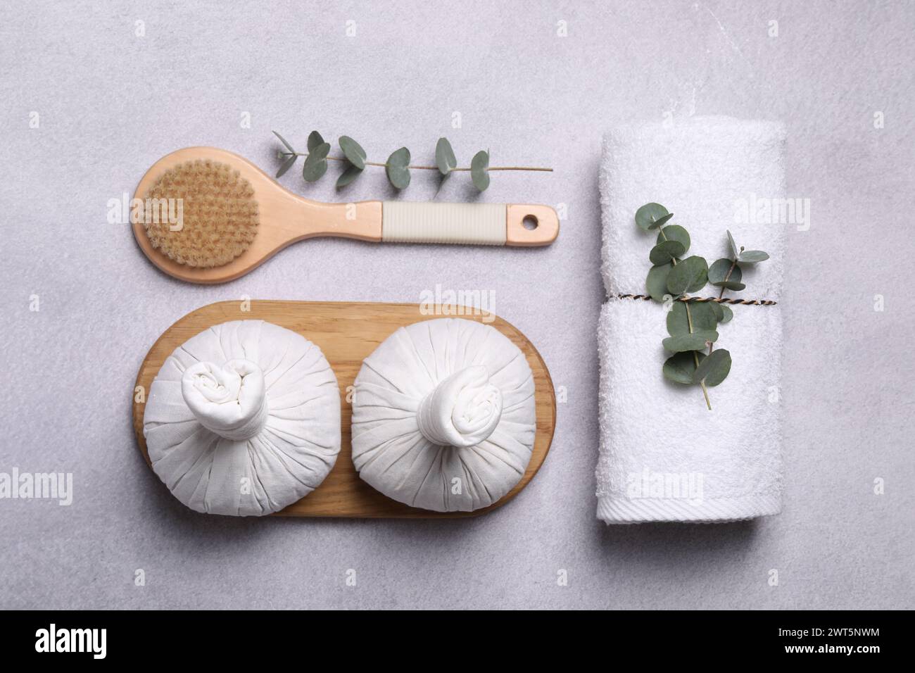 Flat lay composition with spa products and eucalyptus branches on grey ...