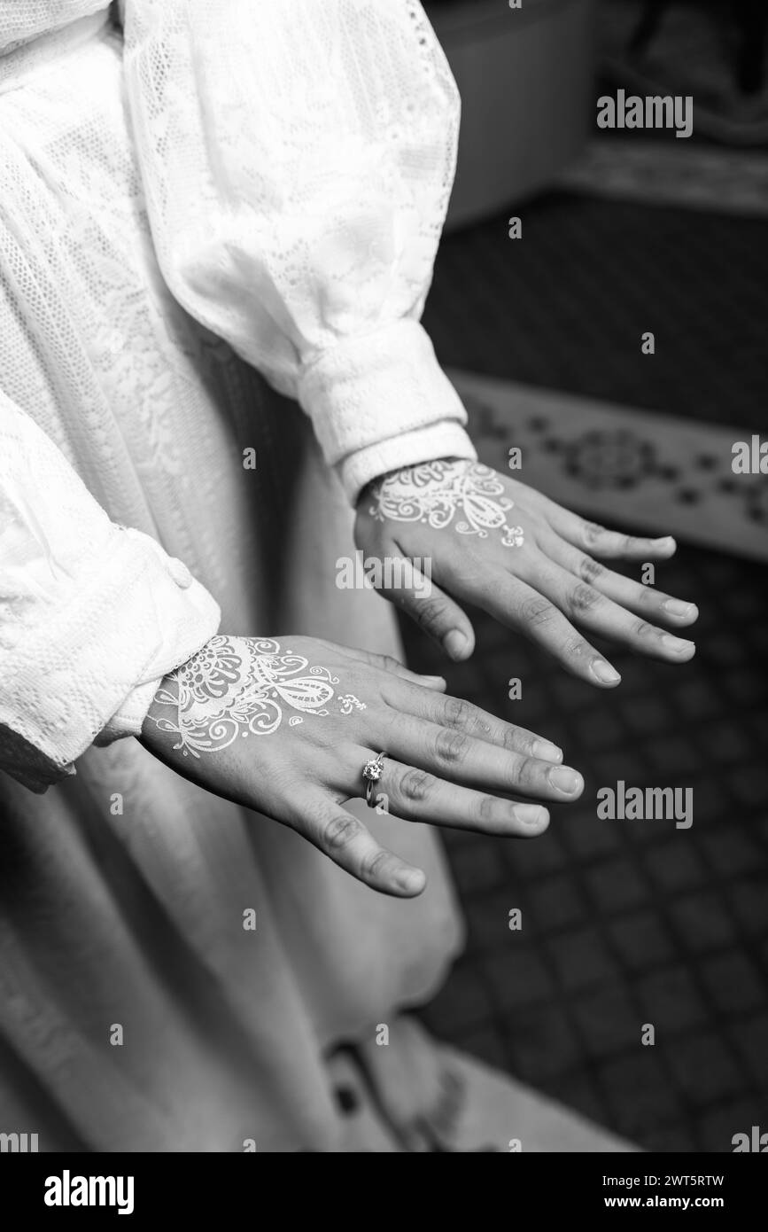 Close up of white henna arts on the bride's hand. bride's hands in